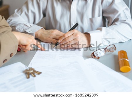 Real Estate Agent holding house key to his client after signing contract. Concept for real estate, business and properties