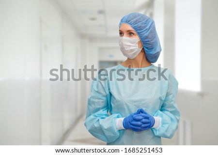 Portrait of doctor in scrubs. A female doctor in a protective cap and face mask in safety measures against the coronavirus. Royalty-Free Stock Photo #1685251453