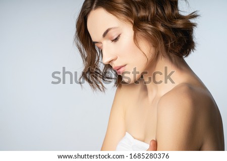 Follow me. Cheerful young female person that bowing her head while being deep in thoughts