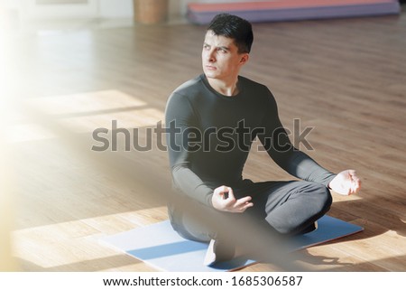 attractive sports guy doing yoga. sun room and shadows. gym and sports. healthy.