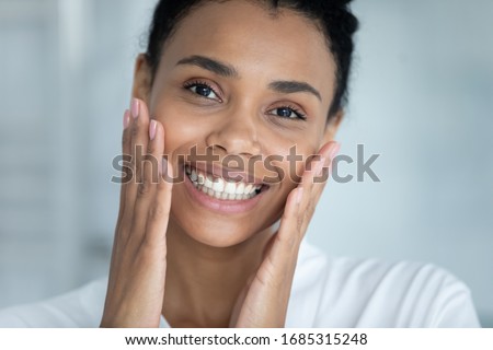 Close up face pretty African woman touches her perfect flawless skin. Result after mask cream beauty spa treatment, aesthetic medicine, chemical peeling, anti wrinkle procedure or product ad concept Royalty-Free Stock Photo #1685315248