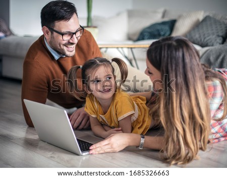 I want cartoons. Happy family having fun at home using laptop.