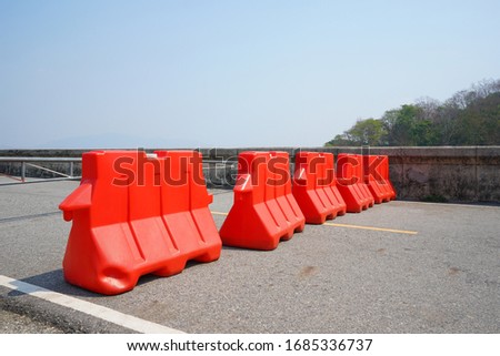 Orange plastic blocks are setting up for road side protection.  Caution, prohibition and traffic regulations.