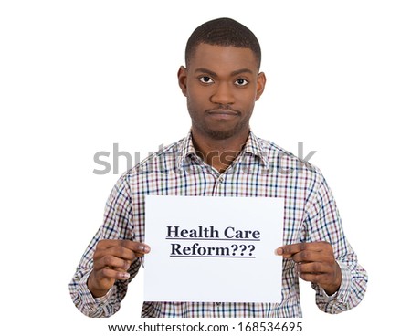 Closeup portrait of a young confused skeptical man holding a sign health care reform, hoping for universal health care coverage, isolated on a white background. politics, government , legislation