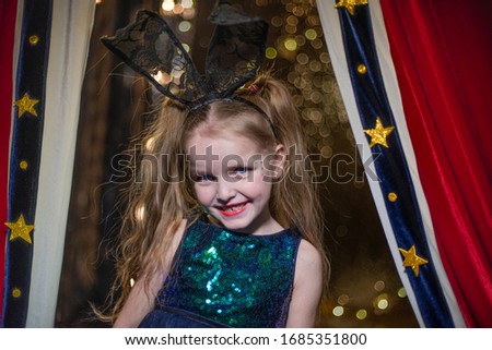 a little girl in a circus looks out from behind a curtain, bokeh