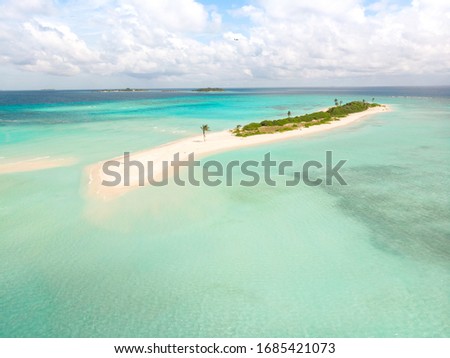 Picture perfect beach and turquoise lagoon on small tropical island on Maldives.