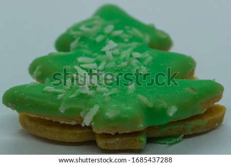 Close-up macro zoom in view of christmas cookies in the form of green Christmas tree with coconut on white background