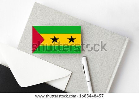 Sao Tome And Principe flag on minimalist letter background. National invitation envelope with white pen and notebook. Communication concept.