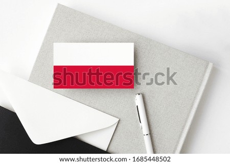 Poland flag on minimalist letter background. National invitation envelope with white pen and notebook. Communication concept.