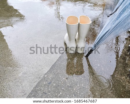 This is a picture of boots and an umbrella.