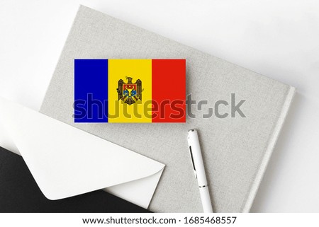 Moldova flag on minimalist letter background. National invitation envelope with white pen and notebook. Communication concept.