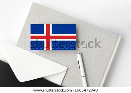 Iceland flag on minimalist letter background. National invitation envelope with white pen and notebook. Communication concept.