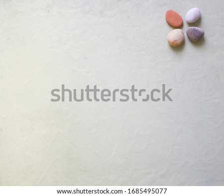 Flat lay image of small stones or pebbles on light pastel green background. Space for copy.