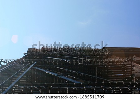 Vertical view from the ground of New York city apartment block fire escape ladders against blue sky