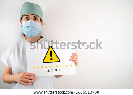 Doctor nurse alerting pandemic alert throughout the world with a sign telling you to stop travelling and staying at home