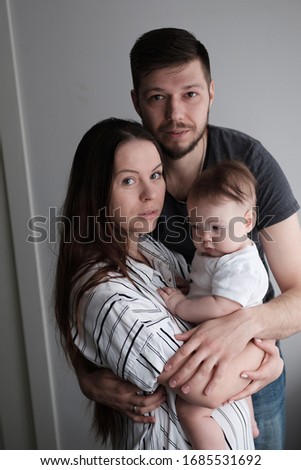 Smiling mother and father holding their newborn baby daughter at home
