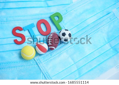 Coronavirus disease or COVID-19 pandemic effects on football, basketball, golf and rugby match. Stop playing sport helps stop the spreading of viruses. Text on blue medical protective face mask Royalty-Free Stock Photo #1685551114