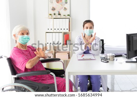 asian female doctor and old patient wear surgical mask and show stop sign or cross sign with hand in hospital, she want to virus protection, healthcare and infection control, corona virus