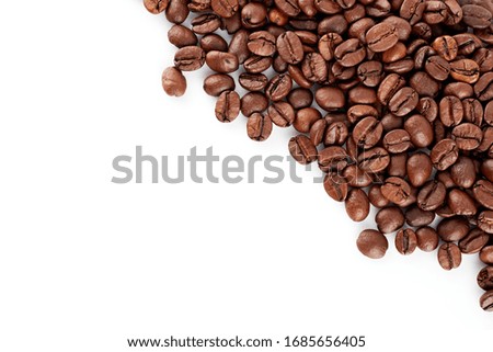 Roasted coffee beans on a white background. The texture of the coffee. An invigorating drink.