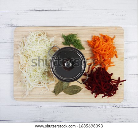 vegetable mix and cooking pot on cutting board on wooden background flat lay. Cooking concept. Image contains copy space