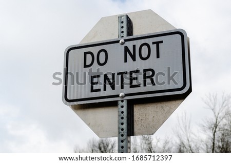 Close-up of Do Not Enter road sign against an overcast sky