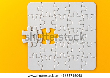 Puzzle pieces on orange background. White square puzzle pieces grid. Business background. Copy space for text, top view.
