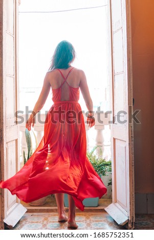 Woman in red dress in her apartments in old Havana at Cuba