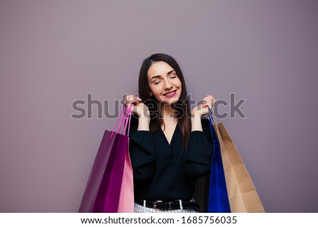 Black Friday sale concept for the store. Shopping woman in sunglasses holding bag isolated on dark background.