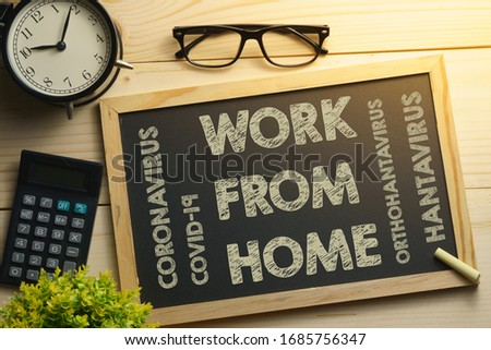 coronavirus conceptual. composition of office supplies on wooden desk wit text WORK FROM HOME. flat lay Royalty-Free Stock Photo #1685756347