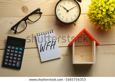 coronavirus conceptual. composition of office supplies on wooden desk with text WFH. flat lay Royalty-Free Stock Photo #1685756353