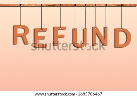 Word refund in orange hanging in big letters on ropes on wood.  
