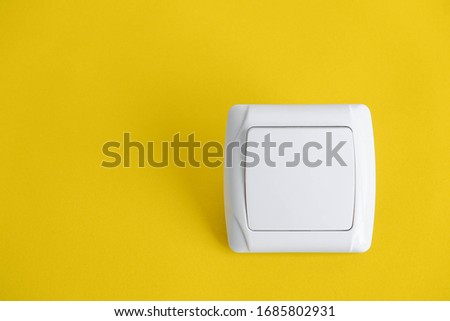 White electro switch on yellow background. Top view. Minimalist Style. Copy, empty space for text