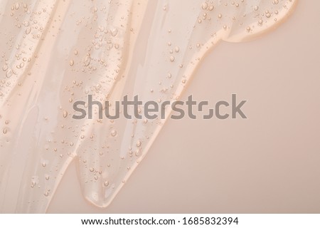 Pure transparent cosmetic gel on beige background, top view Royalty-Free Stock Photo #1685832394