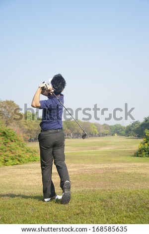 Golfer hits an fairway shot towards the club house ,Golf sport is Balance of Yin Yang.copy space left and right for adding text.