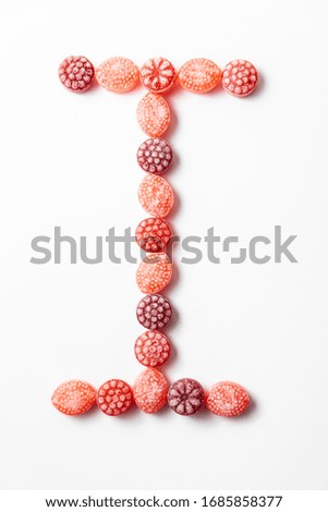Letter I of alphabet homemade by multicoloured berry candies on the white background