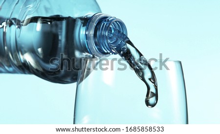 Freeze motion of pouring water from plastic bottle into glass, free space for text