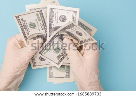 Tax and insurance concept. Top above pov overhead close up photo of hands in rubber gloves holding counting stack of money isolated blue background with copy empty blank space