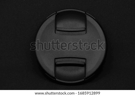 A lens cap in a black background