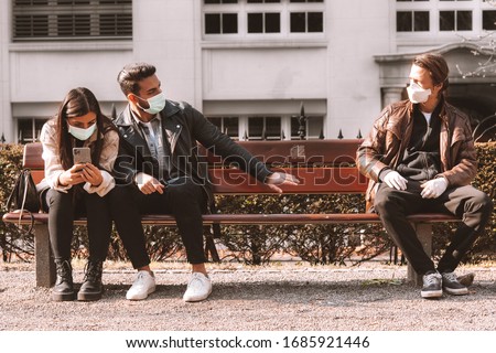 corona covid-19 social distancing concept picture with three people wearing face masks - stay away Royalty-Free Stock Photo #1685921446