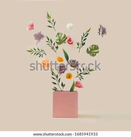 Spring flowers and leaves coming out of pink box. Spring nature concept. Season background idea. Royalty-Free Stock Photo #1685941933