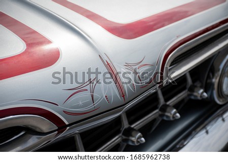 Classic American custom car with red pinstripe paint detailing and chrome grille Royalty-Free Stock Photo #1685962738