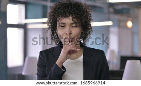 Portrait of African Businesswoman asking to be Quiet by putting Finger on Lips