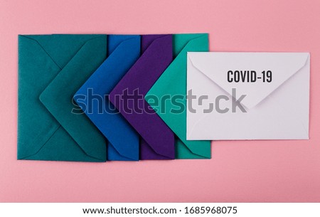 Colorful envelopes on a pink background. Message to the world from Covid-19. COVID-19 crisis and Quarantine concept.