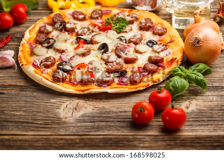 Delicious pizza with sausage, melted cheese and black olives