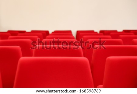rows of red velvet seats in a big hall