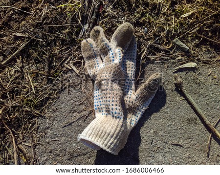 old and dirty work glove is lying on the street