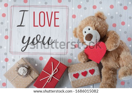 I love you. Greeting card Valentine. Declaration of love. Teddy bear with a heart and boxes with gifts. View from above