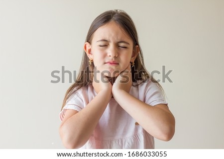 Little girl with sore throat touching her neck.Sore throat sick.Little girl having pain in her throat. Royalty-Free Stock Photo #1686033055