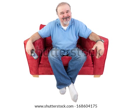 Man sitting in a comfortable armchair with a remote control and a bored expression as he watches something on television that he has seen before