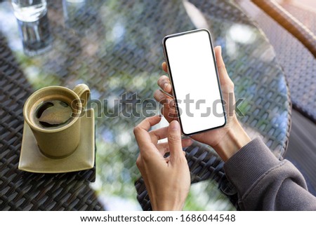 cell phone Mockup image blank white screen.woman hand holding texting using mobile on desk at coffee shop.background empty space for advertise text.people contact marketing business,technology 